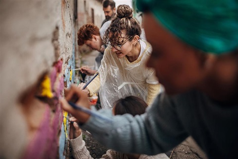Street Artists painting on a wall 